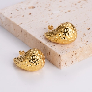 Chubby hammered 18K gold teardrop stud earrings on stone background