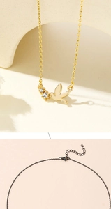 Detail of 18K gold pigeon pendant with zircon inlays and adjustable lobster clasp