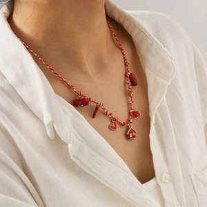 Détail du collier en corde tressée avec pendentifs émaillés rouges cœur et maison