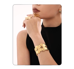 Detail of 18K gold butterfly cuff and ring set featuring brushed metal finish and cutout design
