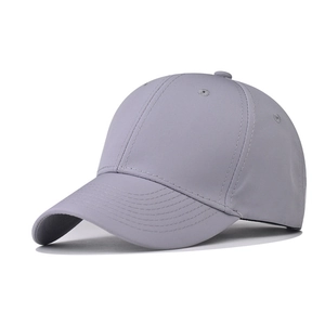 Detail view of a light gray six-panel baseball cap with structured curved brim and vent holes