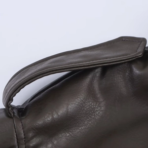Detail of dark faux leather jacket showing lychee grain texture and stitching