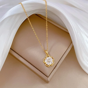 Elegant gold five-petal flower necklace with sparkling zircon pavé on a silk background