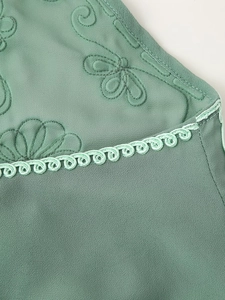 Détail de l'ensemble de vacances vert avec broderie florale et finitions en dentelle tressée