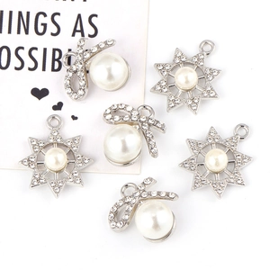 Bowknot and star-shaped alloy pendants with white pearls and rhinestones on white background