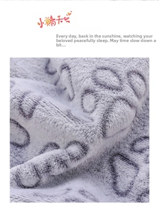 Close-up of soft flannel pet blanket featuring a grey paw print pattern on white fabric