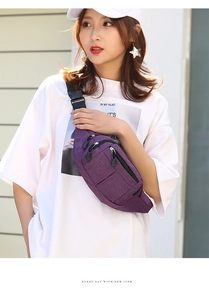 Detail of purple nylon waist bag with multiple zipper pockets and adjustable black strap