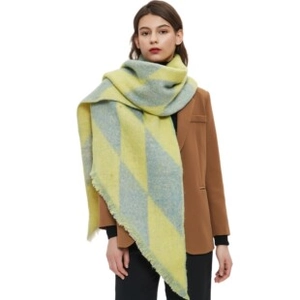 Detail of yellow and light blue checkered wool blend scarf with chunky tassels