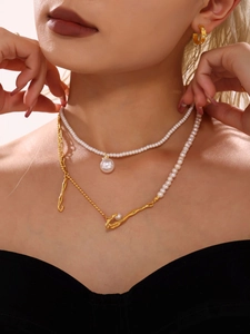 Detailed view of model wearing baroque pearl necklace with gold chain and hoop earrings set