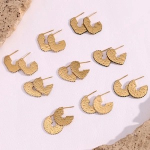 Detailed view of gold geometric earrings with micro-set stones and hammered texture finish