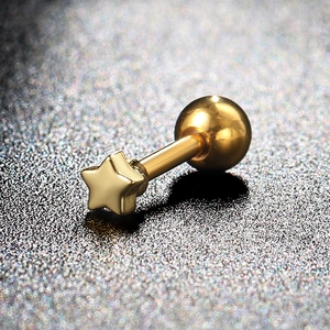 Macro detail of gold star surgical steel cartilage piercing stud with screw back ball