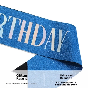 Macro shot of blue glitter fabric birthday sash featuring shiny silver PET lettering