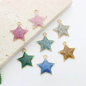 Macro detail of seven colorful glittery star pendants with metal rings for DIY jewelry