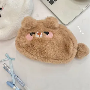 Gros plan d'une trousse en peluche marron avec broderie détaillée et texture douce