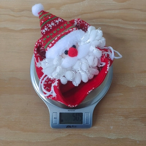 Detailed knit Christmas apple bag with 3D Santa Claus figure on a digital scale