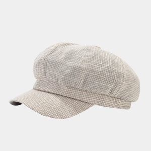 Detail shot of vintage British style octagonal newsboy cap in beige textured tweed