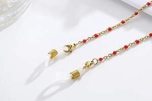 Detailed view of golden glasses chain with red beads and adjustable silicone loops