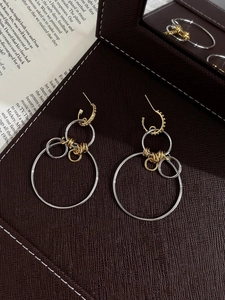 Gros plan de boucles d'oreilles créoles évidées en bicolore or et argent design