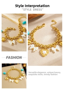 Detail view of gold charm bracelet with pearl bow, heart charms and turquoise stone bead