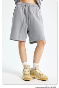 Detail of gray cotton sweat shorts featuring elastic drawstring waist and premium texture