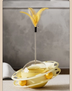 Detail of double-layer rotating track with yellow balls and feather spring toy on top