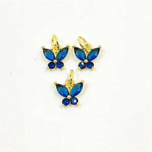Détail de trois pendentifs papillon dorés sertis de pierres de zircon bleu vif