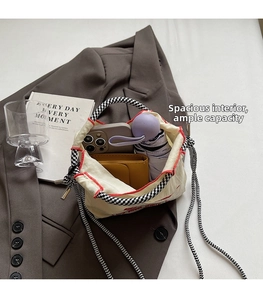 Detail showing the spacious interior of this ivory nylon bag for phones and wallets