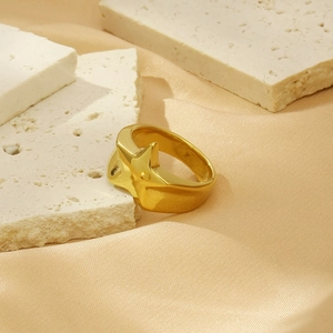 Detail view of bold 18K gold plated geometric ring on elegant silk and stone background