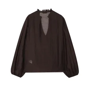 Close-up of deep brown chiffon blouse with ruffles and glossy lantern sleeves