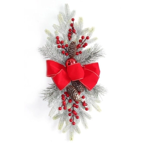 Guirlande d'escalier de Noël avec nœuds rouges, pommes de pin et baies sur branches de pin