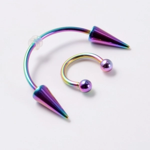 Rainbow stainless steel horseshoe ring and spike piercing jewelry detail on white background