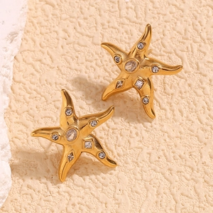 Macro shot of 18K gold starfish earrings encrusted with clear cubic zirconia crystals