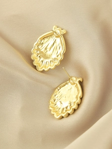 Macro view of the golden shell earring back showing metal texture and stud detail