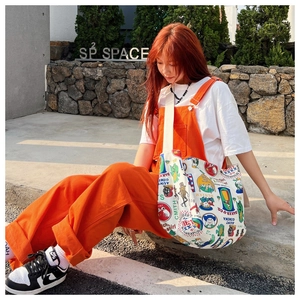 Detail view of large canvas tote bag with retro prints shown on model in outdoor setting