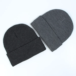 Detail of dark and light gray cuffed knit beanies with fine ribbed texture for winter