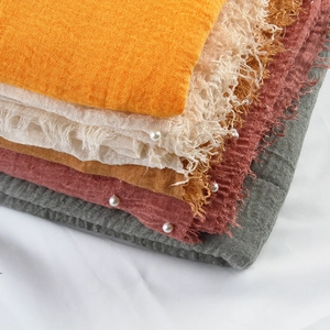 Wrinkled cotton linen scarf with pearl accents and fringe edges in assorted earth tones