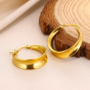 Elegant 18K gold plated stainless steel hollow wave hoop earrings for women on wooden base