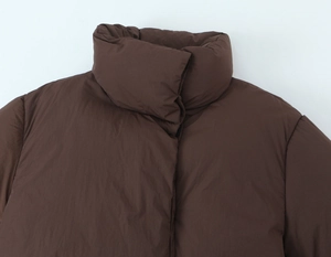 Detailed view of the high stand collar and quilted texture on a brown padded puffer jacket