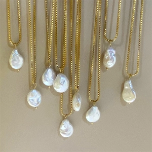 Vue détaillée de pendentifs en perles d'eau douce baroques sur chaînes dorées élégantes