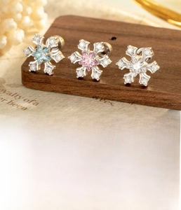 Detailed view of silver snowflake cartilage studs with blue, pink, and white zircons