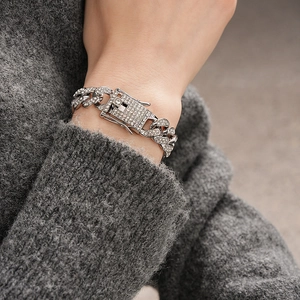 Detail of silver Cuban link bracelet with sparkling rhinestones and a secure clasp on wrist