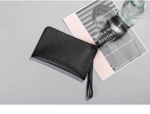 Detail of a black glitter texture clutch bag with wristlet strap in a lifestyle setting