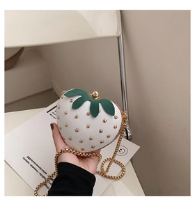 Detail of cute strawberry chain bag with gold studs and green leaf decoration
