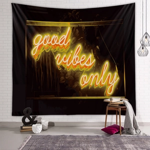 Detail of Good Vibes Only tapestry showing black fabric texture and neon text on white brick wall