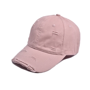 Detail of pink distressed cotton baseball cap showing ripped holes and vintage texture