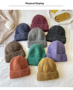 Flat lay of mixed color knit beanies in various colors on a cozy fabric background