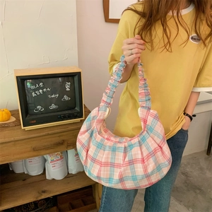 Detail of pink and blue checkered crescent bag with ruffled strap in retro setting