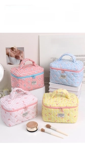 Detailed view of four colorful quilted cosmetic bags with bow patterns and zipper closure