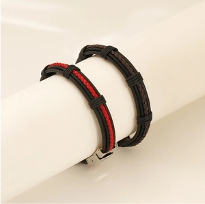 Detail of multi-layer braided leather bracelets with red and brown accents and metal clasp