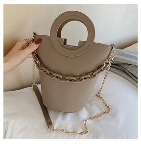 Detailed view of khaki bucket bag with round handle and decorative resin chain strap